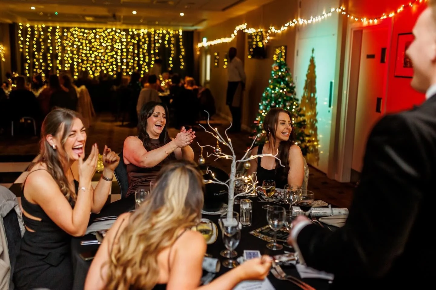 Christmas party guests laughing and reacting to close-up magic